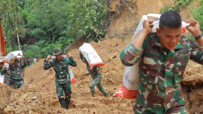BANTUAN BENCANA SUMATERA - Prajurit TNI dari Satuan Tugas (Satgas) Yonif 122/Tombak Sakti (TS) Kodam I/BB memikul bantuan dan berjalan kaki demi menjangkau desa terisolir di Kecamatan Sitahuis, Kabupaten Tapanuli Tengah pada Selasa (2/12/2025).