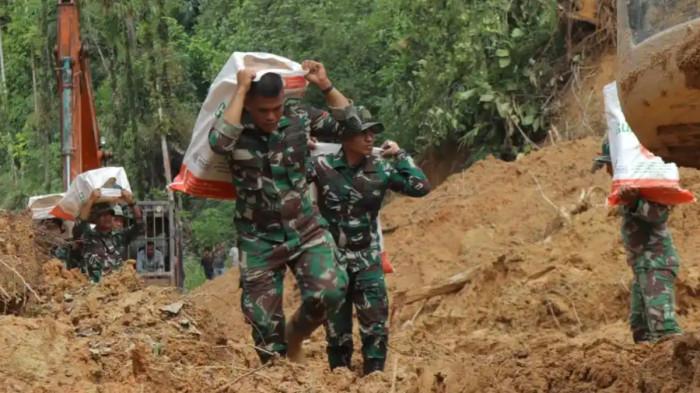 BANTUAN BENCANA SUMATERA  - Prajurit TNI dari Satuan Tugas (Satgas) Yonif 122/Tombak Sakti (TS) Kodam I/BB memikul bantuan dan berjalan kaki demi menjangkau desa terisolir di Kecamatan Sitahuis, Kabupaten Tapanuli Tengah pada Selasa (2/12/2025).