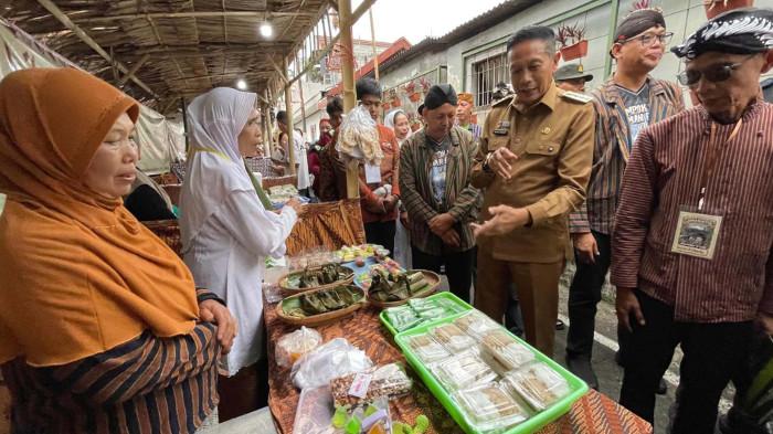 UMKM -  Wali Kota Malang, Wahyu Hidayat (dua dari kanan) didampingi Ketua Panitia, Agus Riyanto (kanan) meninjau stand UMKM pada gelaran Klampok Kasri Jaman Biyen (KJB) Jilid 4 di RW 02 Kelurahan Gading Kasri, Kecamatan Klojen, Kota Malang, Selasa (9/9/2025).