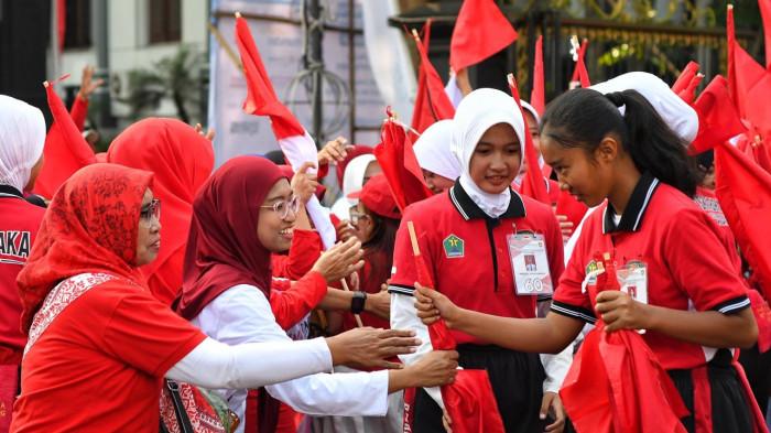MERAH PUTIH - Warga menerima bendera Merah Putih seusai dibagikan secara serentak di halaman Balai Kota Malang, Jawa Timur, Jumat (8/8/2025).