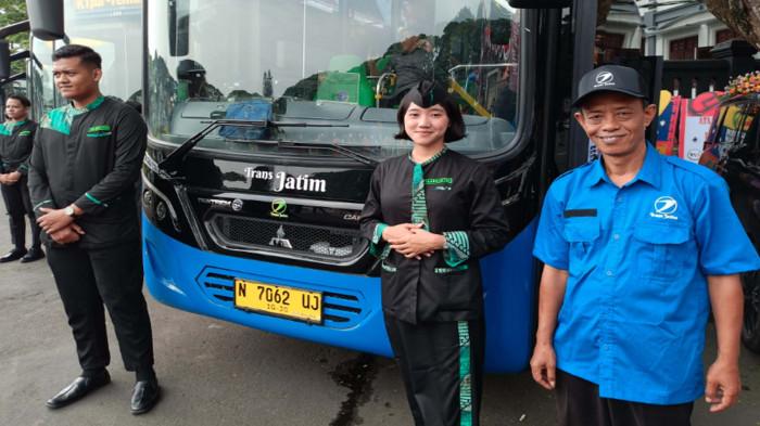 BANGGA - Rudianto (Seragam Biru), pengemudi Bus Trans Jatim yang sebelumnya mengemudikan angkutan kota, Kamis (20/11/2025). Ia mengungkapkan bahwa pola pikir pengemudi kini harus berbeda dibanding saat mengemudikan mikrolet.Saat menjadi sopir bus Trans Jatim, Rudi harus bisa melayani penumpang dengan ramah.