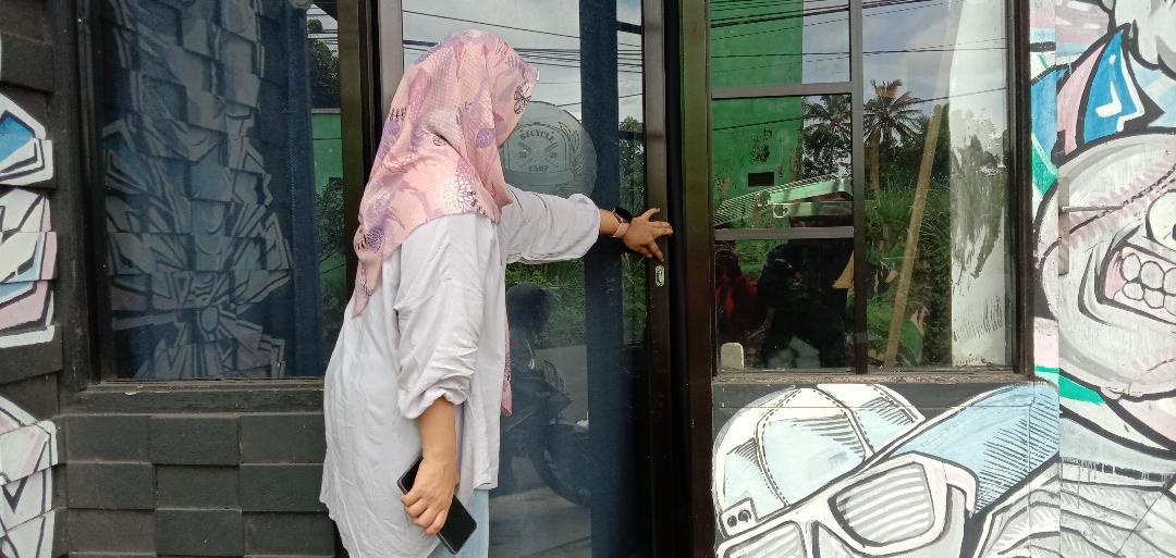 Pemilik-toko-di-Kota-Malang-saat-menunjukkan-pintu-toko-yang-dibobol-oleh-pelaku.jpg