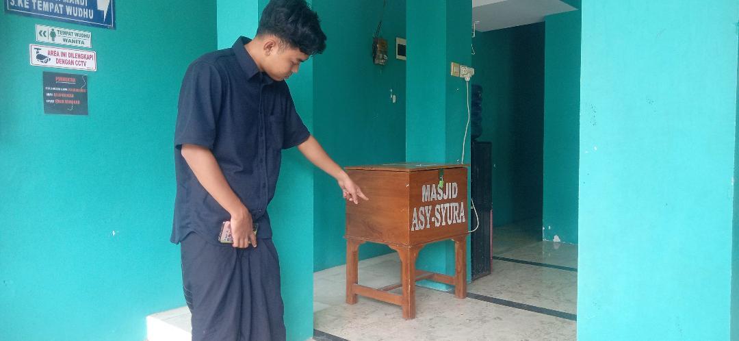 Takmir-Masjid-Asy-Syuura-Kota-Malang-Supratman-menunjukkan-kotak-amal-yang-dicuri-tiga-bocil.jpg
