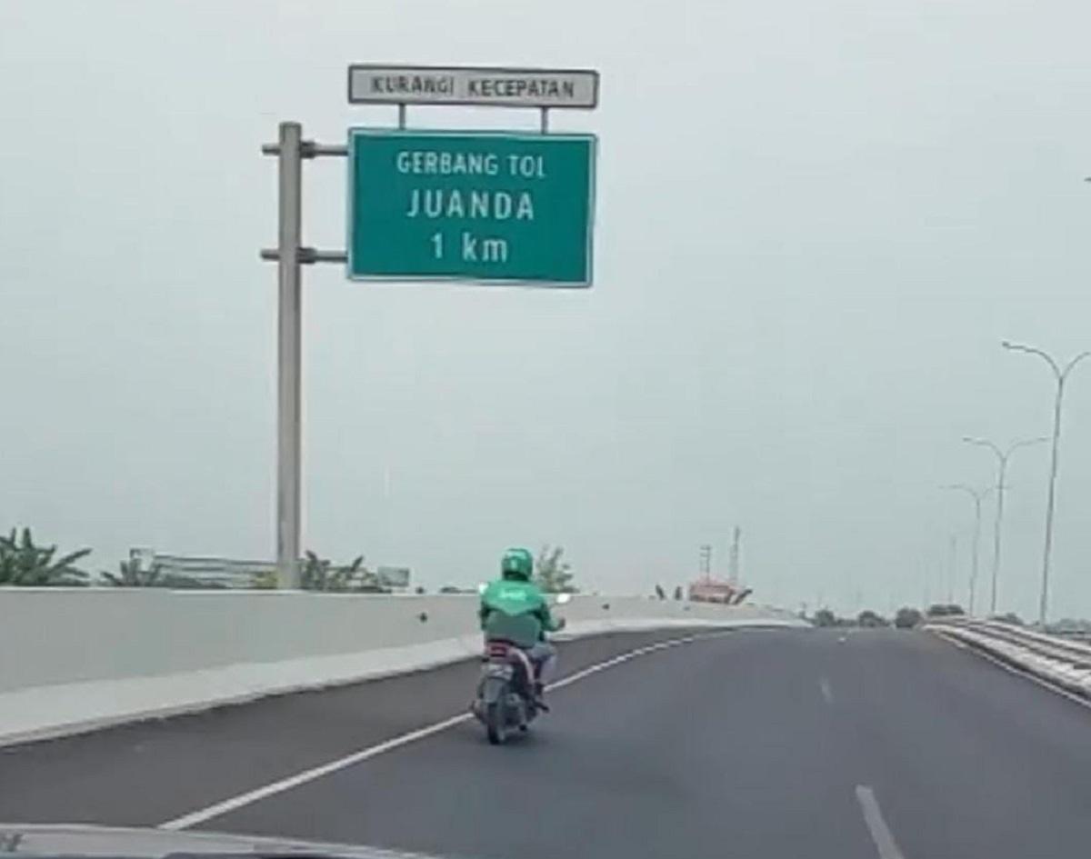 Tangkapan-layar-pemotor-beratribut-ojol-saat-melenggang-di-ruas-Tol-Juanda.jpg