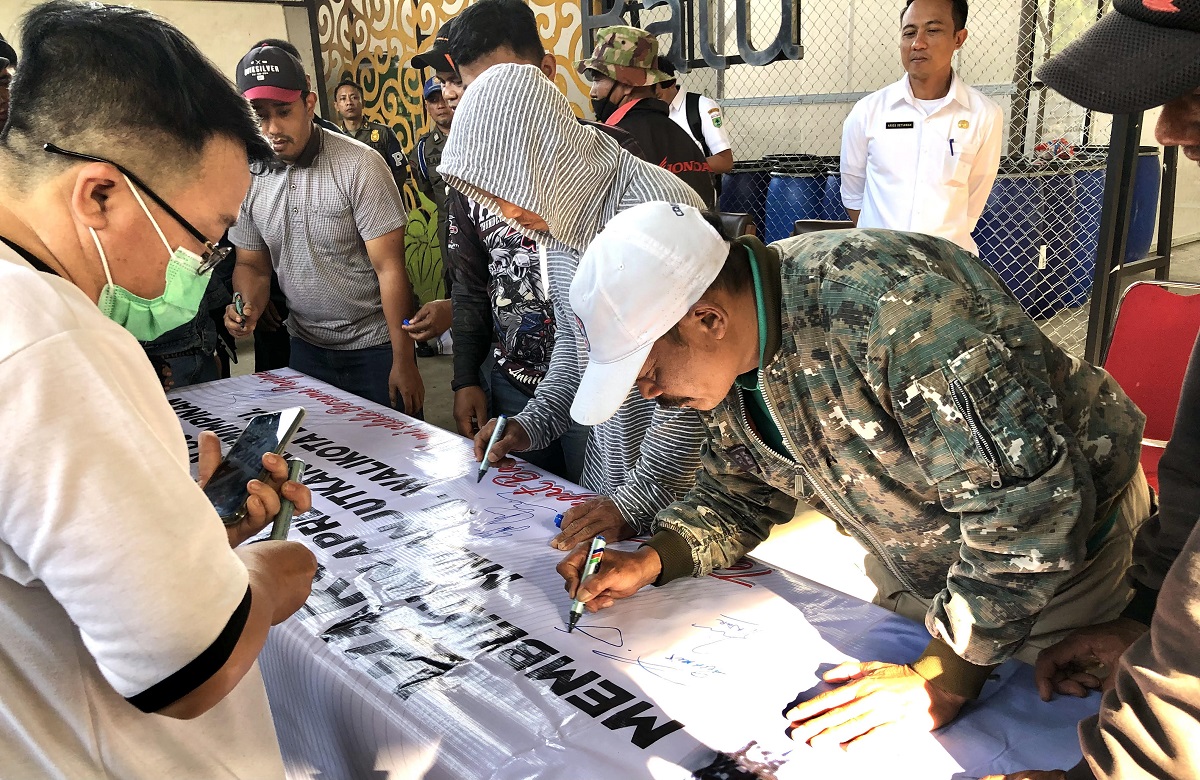 warga-tanda-tangan-di-spanduk-dukungan-pada-aries-paewai.jpg