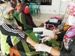 mamik-setiawai-kepala-sekolah-smp-2-senduro-saat-melakukan-vaksinasi-covid-19.jpg