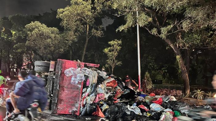TRUK SAMPAH TERGULING- Truk sampah terguling di depan warung bebek goreng di Jalan Ciater, Serpong, Kota Tangerang Selatan, Sabtu (7/3/2026) pukul 00.30 WIB. Peristiwa itu sempat membuat sampah berserakan dan arus lalu lintas macet (TribunTangerang.com - Wartakota Network/Ikhwana Mutuah Mico)