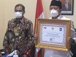 Gubernur-Banten-Wahidin-Halim-memegang-penghargaan-Mendagri-Tito-Karnavian.jpg