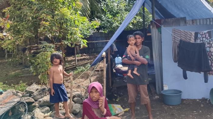 PENGUNGSI: M. Risal Sagule dan anak-anaknya berada di depan tenda setelah rumah mereka di Desa Wayamiga, Kecamatan Bacan Timur, Halmahera Selatan terbakar pada 25 November 2025.