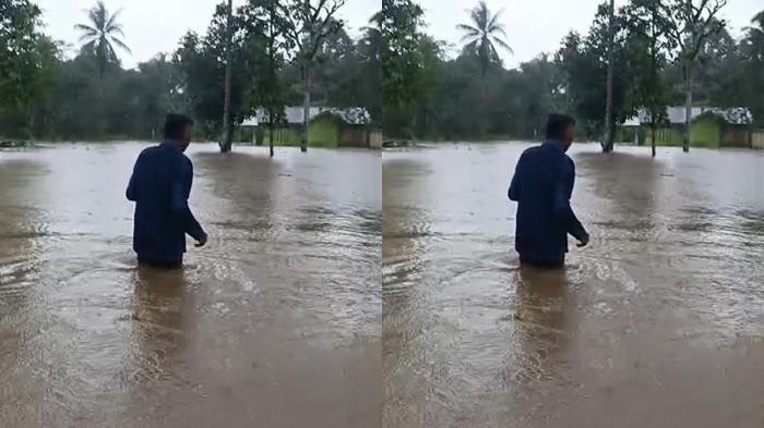 BENCANA: Tampak seorang warga Desa Sumber Makmur, Kecamatan Gane Timur, Halmahera Selatan menyebrangi banjir, Rabu (3/12/2025)