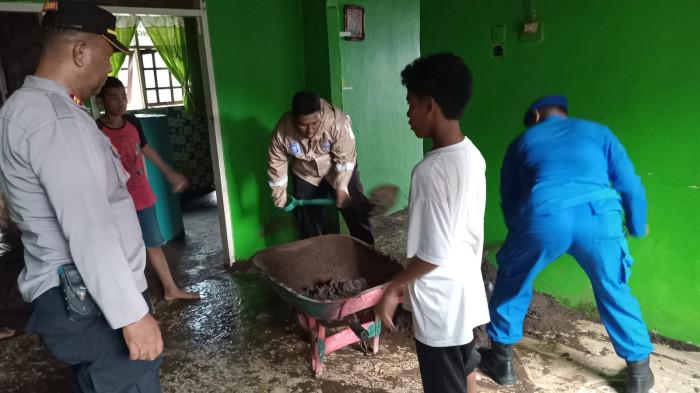 BENCANA: Kapolsek Pulau Ternate Iptu Lukman Umasugi bersama salah satu anggota Polairud Polda Maluku Utara membersihkan lumpur di salah satu rumah warga terdampak banjir di Kelurahan Tafraka, Kecamatan Pulau Hiri, Selasa (13/1/2026)