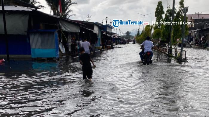 BENCANA: Tampak salah satu kendaraan roda dua berupaya menerobos banjir di kawasan Pasar Labuha, Halmahera Selatan, Minggu (7/12/2025)