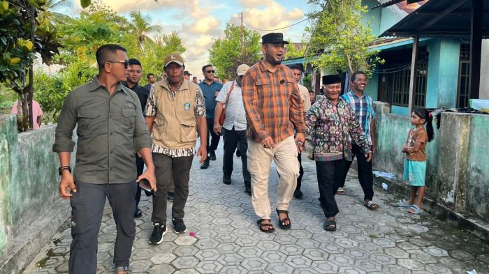 Bupati Halmahera Selatan Bassam Kasuba (kameja kotak-kotak) ketika berjalan mengecek infrastruktur Desa Buli, Kamis (4/12/2025).