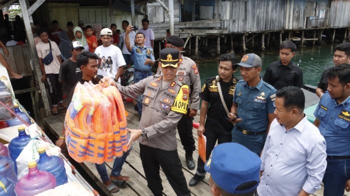 SIGAP: Kapolres Halmahera Selatan AKBP Hendra Gunawan ketika mengangkat life jacket saat pemeriksaan speedboat di Pelabhan Habibi, Desa Labuha, Kecamatan Bacan, Rabu (18/3/2026). Apa yang dilakukan ini merupakan rangkaian pengamana mudik lebaran