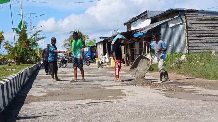 INISIATIF: Warga bahu-membahu tambal jalan berlubang dikawasan Pasar Tradisional Bobong, Pulau Taliabu, Jumat (15/5/2026)