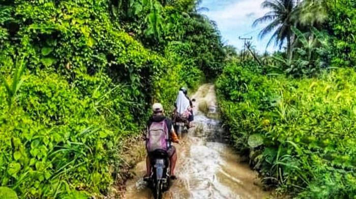 JALAN - Warga melintasi jalan Bibinoi-Wayatim, Halmahera Selatan menggunakan kendaraan roda dua. Forpmasi Wayatim minta Gubernur Maluku Utara, Sherly Laos, beri atensi, Jumat (27/2/2026).