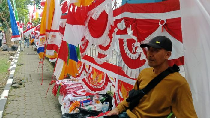 KEMERDEKAAN: Agus Suryaman (52) salah satu pedagang bendera merah-putih di kawasan Taman Fitnes, Kelurahan Kalumpang, Ternate Tengah, Maluku Utara, Minggu (3/7/2025)