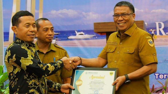PENGHARGAAN - Sekretaris Daerah Kota Tidore Kepulauan Drs. H. Ismail Dukomalamo menerima penghargaan dari Badan Penyelenggaraaan jaminan Sosial (BPJS) yang telah berkontribusi Aktif Dalam Program JKN-KIS-BPJS Kesehatan