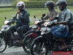 pengguna-sepeda-motor-memakai-jas-hujan-saat-hujan-tiba.jpg