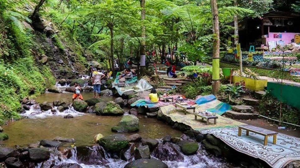 Pengunjung bisa makan di tepi sungai yang segar di kawasan wisata Air Terjun Jumog, Karanganyar, Jawa Tengah.