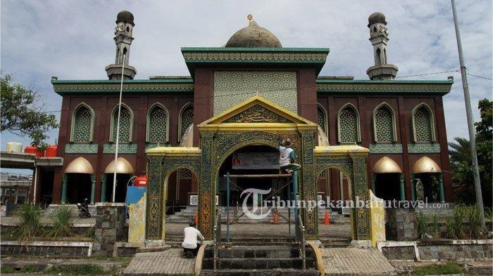 Pekerja tengah mengecat tulisan kaligrafi pada pintu gerbang Masjid Raya Pekanbaru, Minggu (13/9/2020).