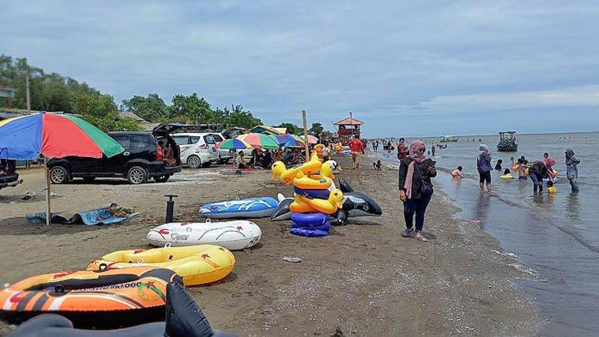 Masyarakat menikmati liburan ke Pantai Samudra Baru, Karawang, pada Sabtu (26/12/2020).
