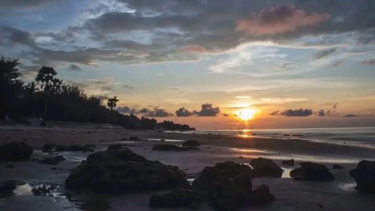 Pemandangan sunset cantik di Pantai Slopeng, tempat wisata alam di Sumenep, Jawa Timur.