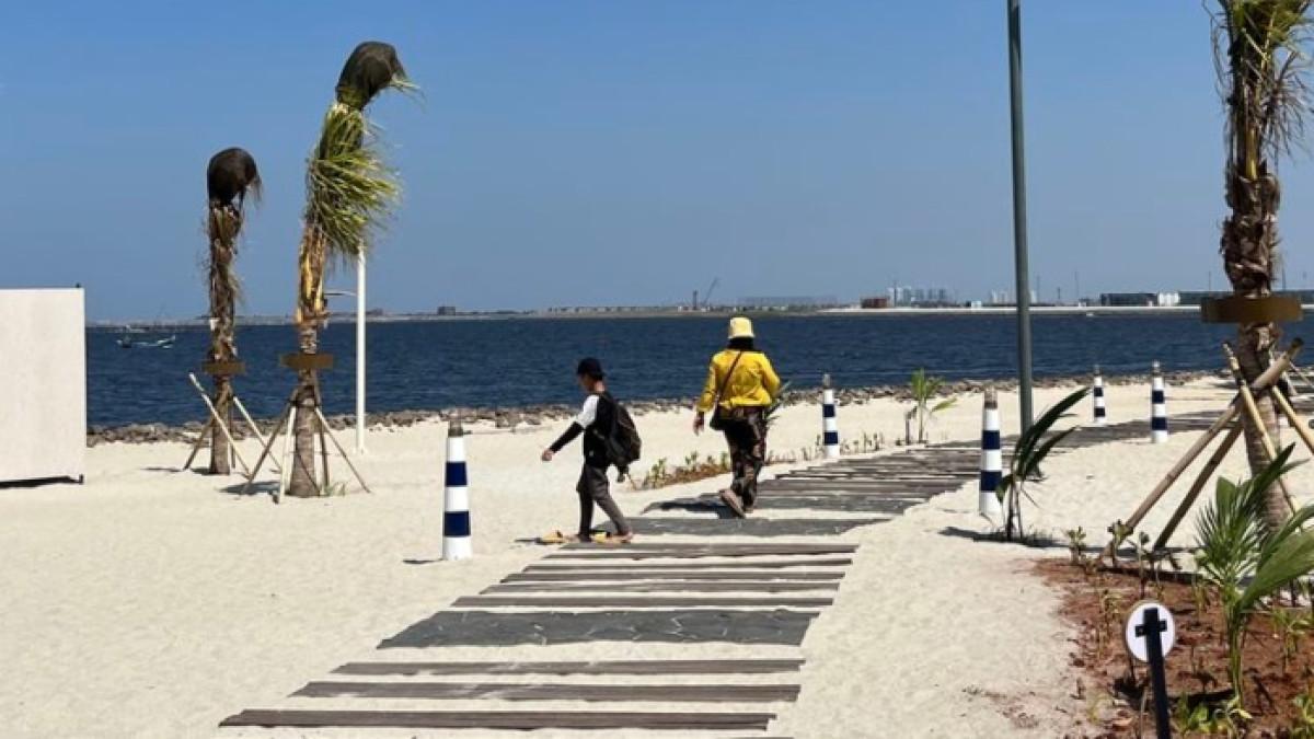 Pengunjung Land's End sedang berpose dengan landskap mercusuar, di Pantai Indah Kapuk 2, Jakarta Utara, Rabu (20/12/2023).