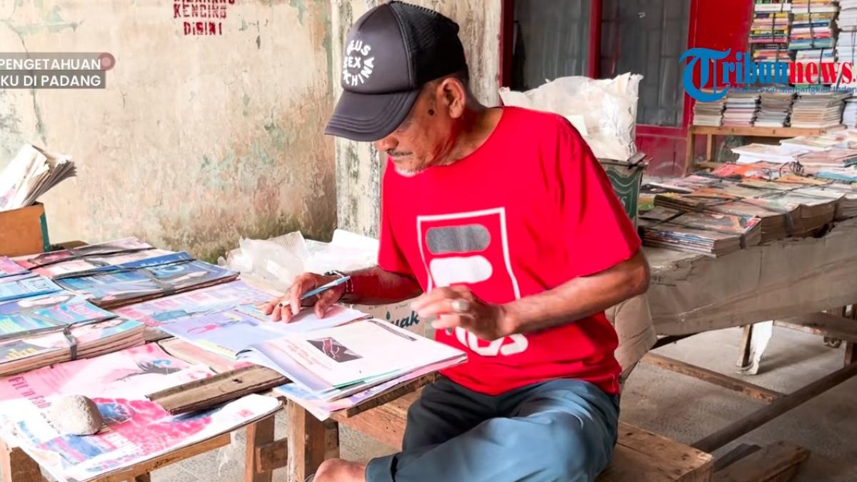 Pengunjung di Padang Teater memeriksa isi buku bekas halaman demi halaman sebelum memutuskan membeli.