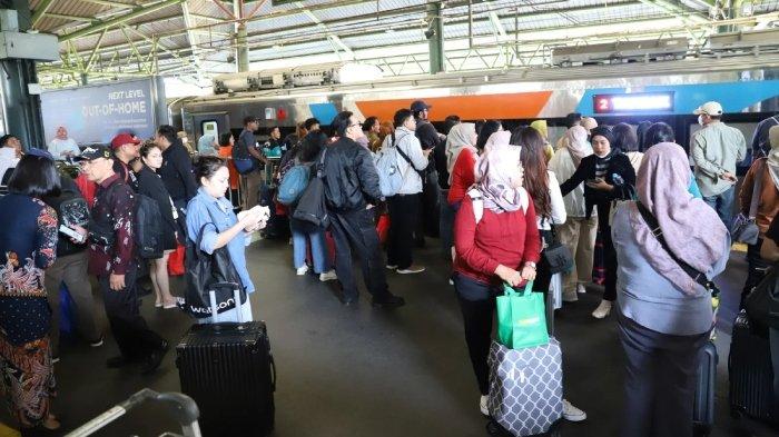 Penumpang kereta api antre di stasiun.