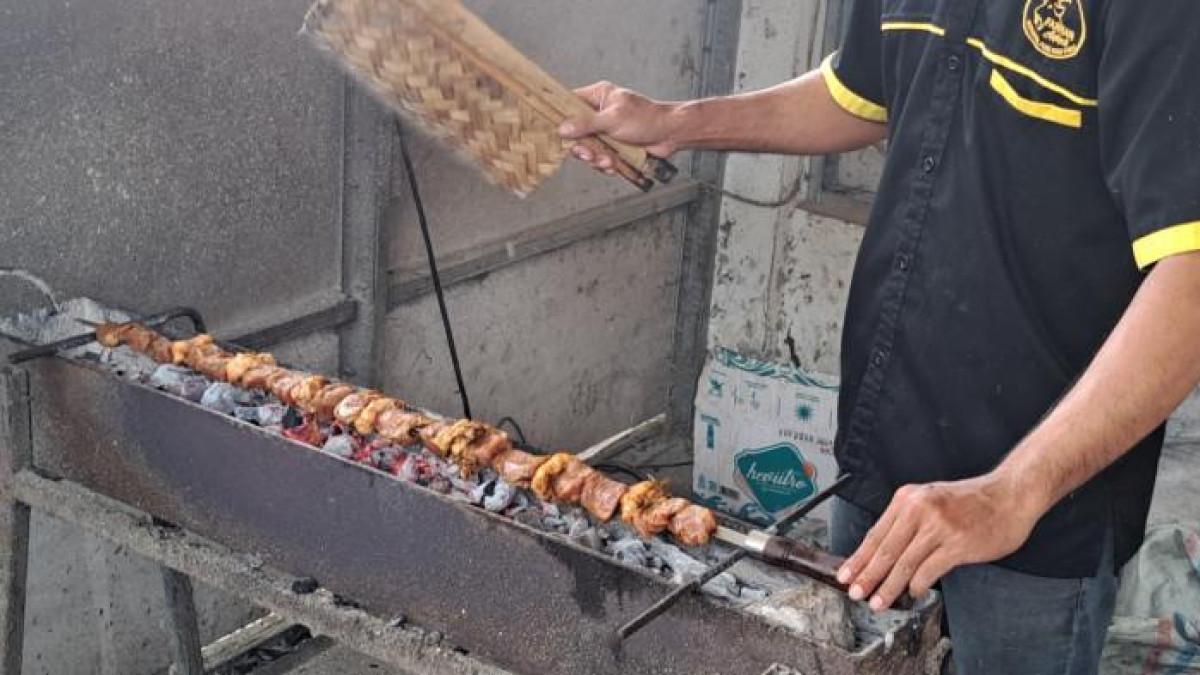 SATE TUSUK PEDANG - Penampakan sate kambing tusuk pedang sepanjang 1 meter di outlet Sate KMC, Jalan Jatisari, Kelurahan Sumampir, Kecamatan Purwokerto Utara, Kabupaten Banyumas, Senin (20/10/2025). Sate ini diklaim sebagai sate kambing terpanjang se-Indonesia dan sudah didaftarkan ke Hak Kekayaan Intelektual (HAKI).