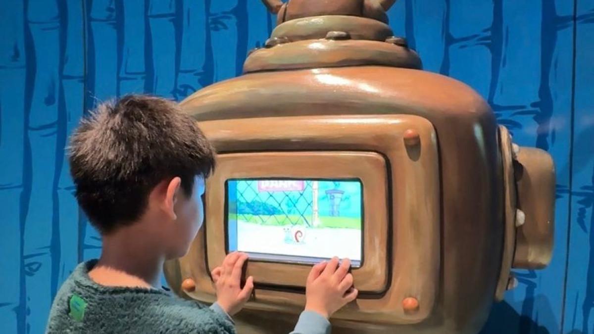 Seorang anak menjelajahi permainan digital bertema SpongeBob di Nickelodeon Playtime SPARK.