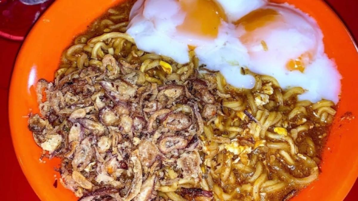 Seporsi Mie Bangladesh dengan topping telur setengah matang.