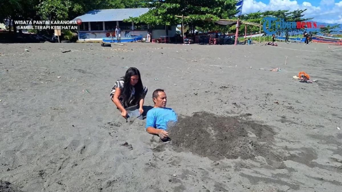 Terapi pasir di Pantai Karangria Manado, Sulawesi Utara.