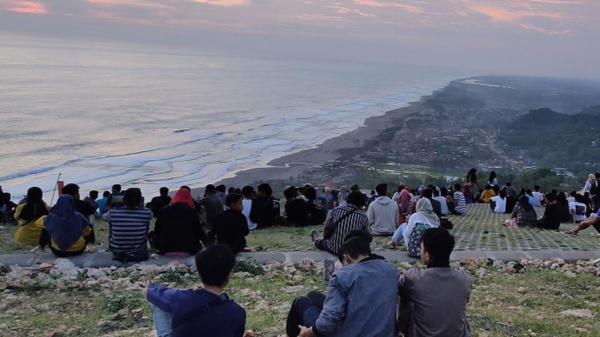 Wisatawan menikmati pemandangan sunset di Bukit Paralayang Watugupit, Bantul, Jogja, Kamis (23/1/2020)