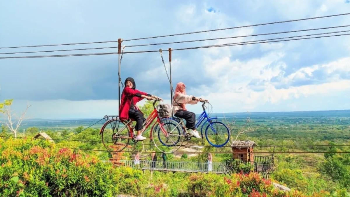 Wisatawan nyobain wahana permainan di Boekit Tinggi Daramista Sumenep, Jawa Timur.
