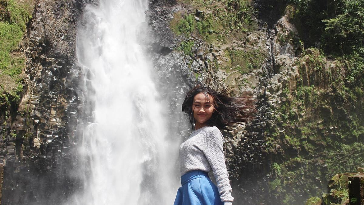Wisatawan yang berpose dengan latar belakang Air Terjun Takapala, Gowa, Sulawesi Selatan