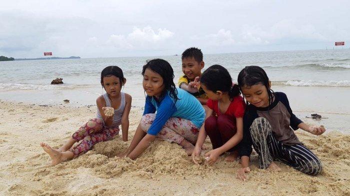 Anak-anak sedang bermain pasir di Pantai Setokok, Batam