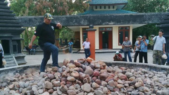 Pengunjung menguji nyali dengan berjalan di atas Batu Kayangan Api di Bojonegoro, Jawa Timur.