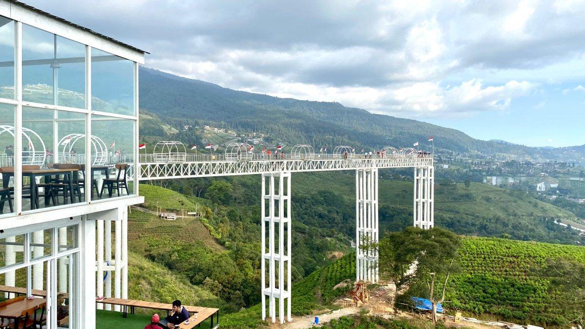 Wisatawan menaiki jembatan kaca viral di Kemuning Sky Hills, Karanganyar, Jawa Tengah pada Jumat (11/8/2023).