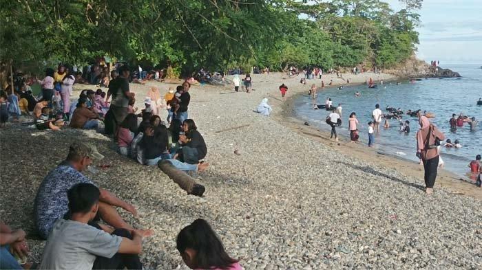 Suasana ramai pengunjung menikmati liburan di Pantai Dami, Bolsel, Sulawesi Utara yang terkenal dengan hamparan kerikil eksotis di tepi laut.