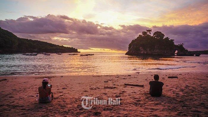Dua orang wisatawan tampak menikmati keindahan Pantai Crystal Bay di Desa Sakti, Nusa Penida, Bali, Minggu (21/4/2019).