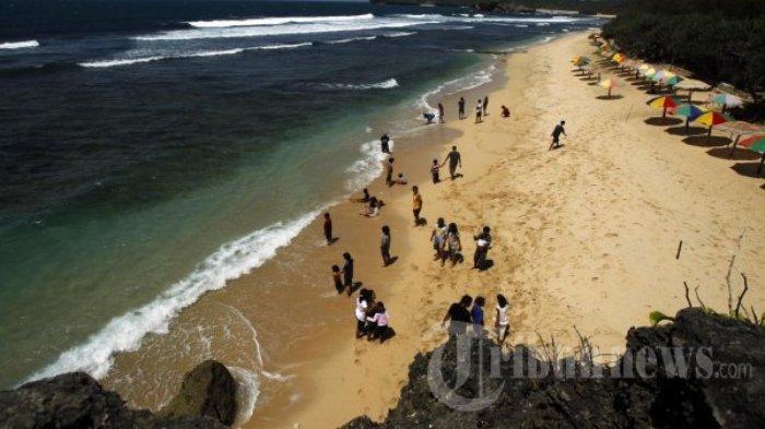 Wisatawan menikmati deburan ombak dan pasir putih di Pantai Pulang Sawal atau yang lebih dikenal dengan sebutan Pantai Indrayanti, Gunungkidul, Jogja