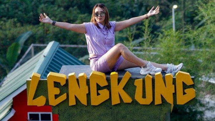 Pengunjung yang berpose di atas Plakat Lengkung Langit Lampung