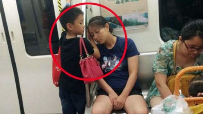 Mengharukan! Anak Laki-laki Ini Biarkan Ibunya Bersandar Pada Tangannya Saat Kelelahan di Kereta Api