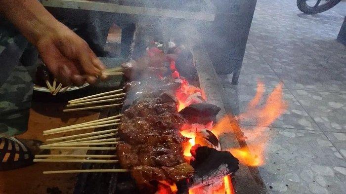 Sate kambing yang tengah dibakar sebelum disajikan ke pengunjung.