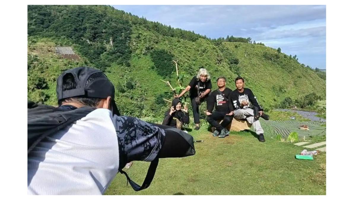 FOTO BERLATAR BUKIT - Peserta tracking kawasan Guci, Kabupaten Tegal, Jawa Tengah, menyempatkan berfoto berlatar pemandangan perbukitan yang indah saat menyusuri perbukita, Jumat (7/11/2025). Tracking perbukitan menjadi wisata baru di kawasan Guci selain pemandian air hangat.