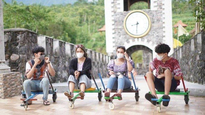 Wisatawan mencoba wahana mini kereta tradisional atau mirip luge di The Lost World Castle