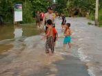 Petugas-kepolisian-memantau-warga-berwisata-di-lokasi-banjir-di-Rengat-Barat-Indragiri-Hulu-Riau.jpg