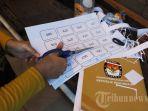 Petugas-panitia-pemungutan-suara-PPS-menggunting-nomor-antrian-pemungutan-suara.jpg